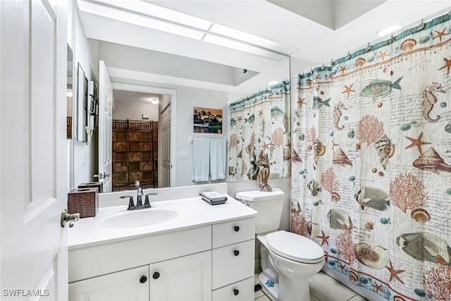 bathroom with tile patterned flooring, vanity, toilet, and walk in shower