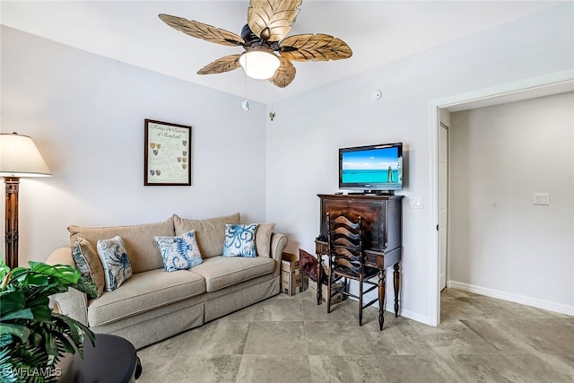 living area with baseboards and a ceiling fan