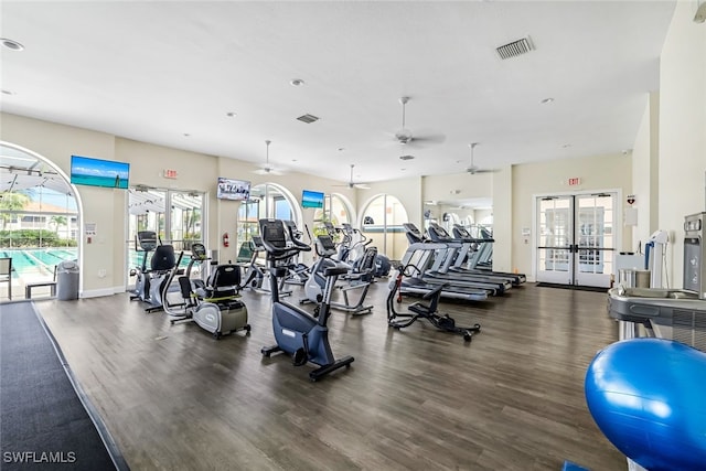 gym with dark wood-type flooring, ceiling fan, a healthy amount of sunlight, and french doors