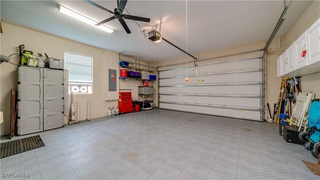 garage with a garage door opener, electric panel, and ceiling fan