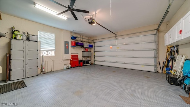 garage featuring electric panel, a ceiling fan, and a garage door opener