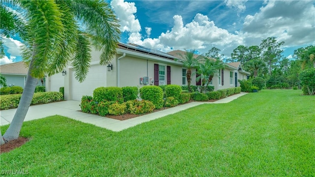 view of side of home with a garage, solar panels, and a lawn