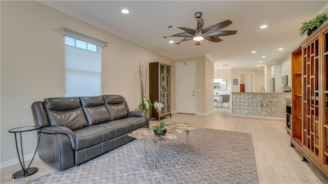 living room with ceiling fan, ornamental molding, and light hardwood / wood-style floors