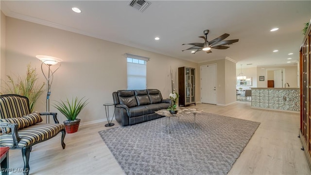 living room with ceiling fan, ornamental molding, and light wood-type flooring