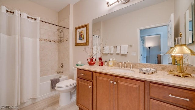 bathroom featuring toilet, shower / bath combo with shower curtain, and vanity