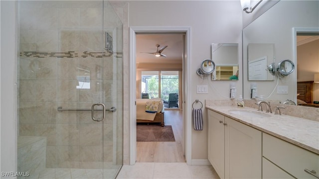 bathroom with an enclosed shower, vanity, and tile patterned flooring