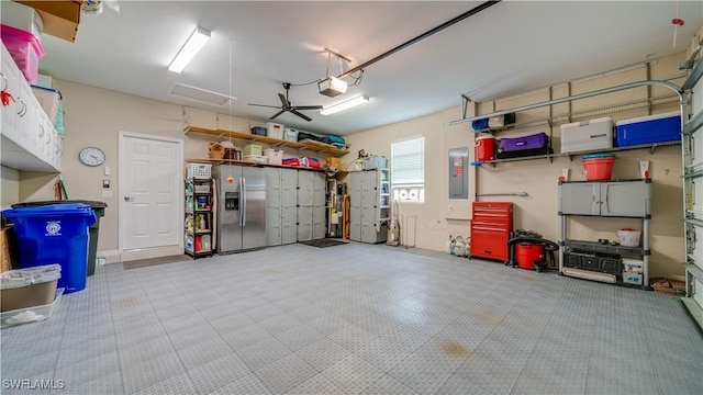 garage with electric panel, stainless steel refrigerator with ice dispenser, and a garage door opener