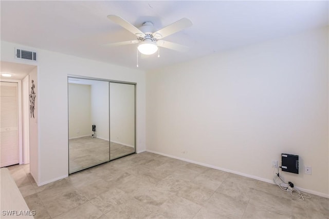 unfurnished bedroom with ceiling fan and a closet