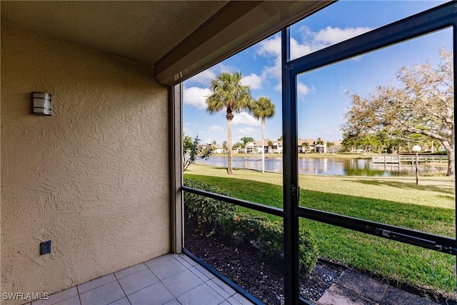 unfurnished sunroom featuring a water view