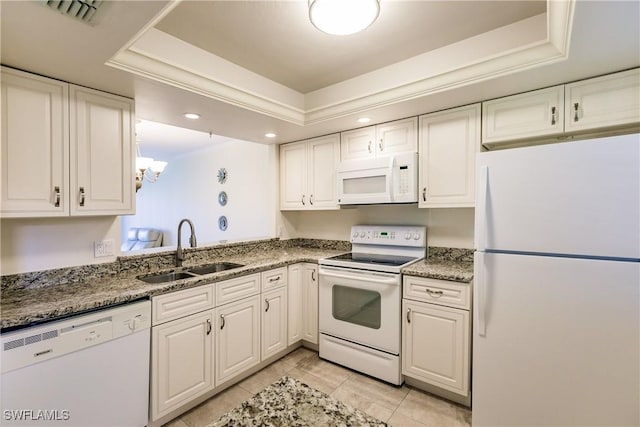 kitchen with white cabinets, white appliances, sink, and a tray ceiling