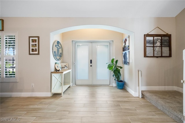 foyer entrance with light hardwood / wood-style flooring and french doors