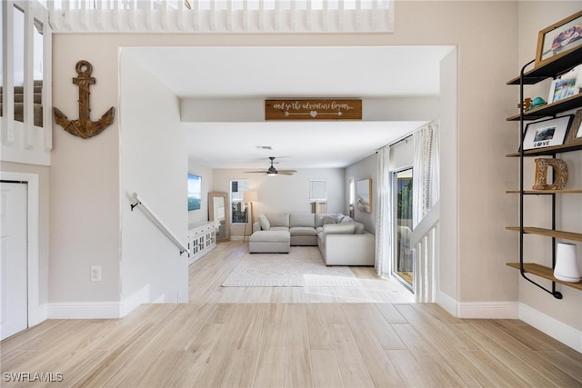 living room with light hardwood / wood-style flooring and ceiling fan