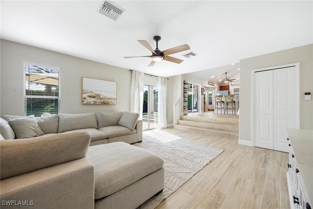 living room with light hardwood / wood-style flooring and ceiling fan