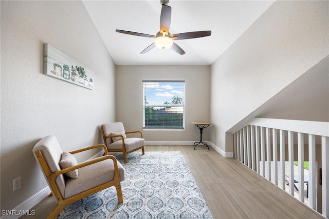 living area featuring ceiling fan, light wood-type flooring, and lofted ceiling