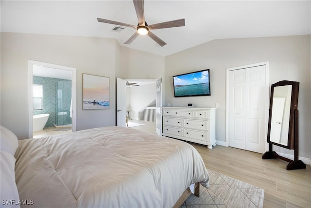 bedroom with ceiling fan, ensuite bathroom, light hardwood / wood-style floors, and lofted ceiling