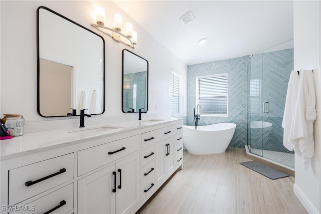 bathroom featuring separate shower and tub and vanity