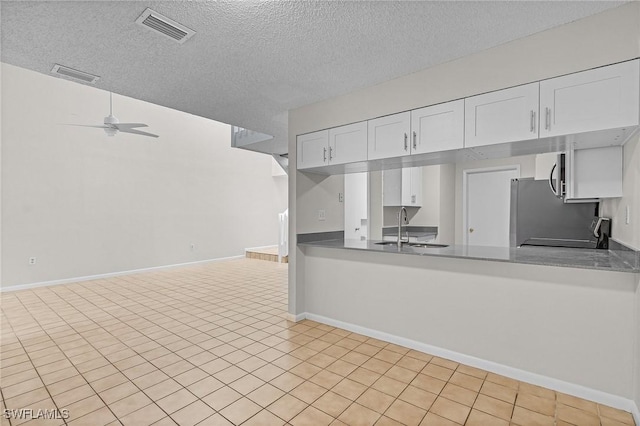 kitchen featuring white cabinetry, sink, ceiling fan, and a textured ceiling