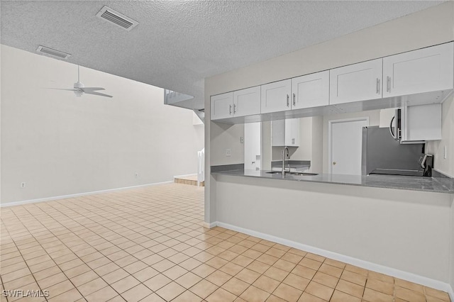 11653 Pointe Circle Dr, Fort Myers, FL 33908 - kitchen with a textured ceiling, white cabinets, a ceiling fan, a peninsula, and refrigerator