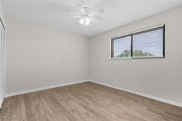 unfurnished room featuring ceiling fan, a textured ceiling, and light wood-type flooring