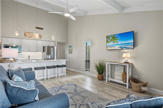 living room featuring ceiling fan, light hardwood / wood-style flooring, beam ceiling, and wooden ceiling