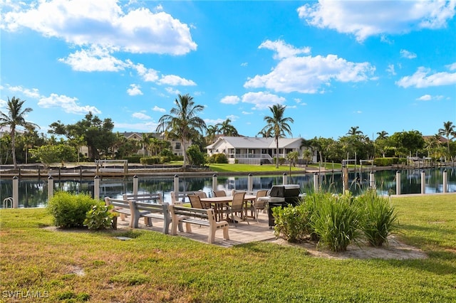 dock area featuring a lawn, a patio, and a water view