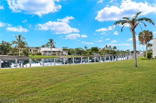 view of home's community with a water view and a yard