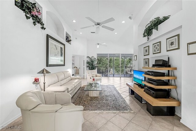 living room featuring ceiling fan, a towering ceiling, and light tile patterned floors