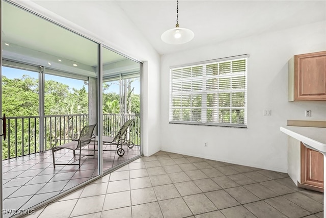 unfurnished sunroom featuring a healthy amount of sunlight and lofted ceiling