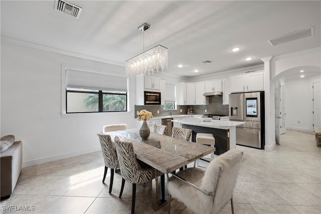 dining room with ornamental molding, light tile patterned floors, and a chandelier