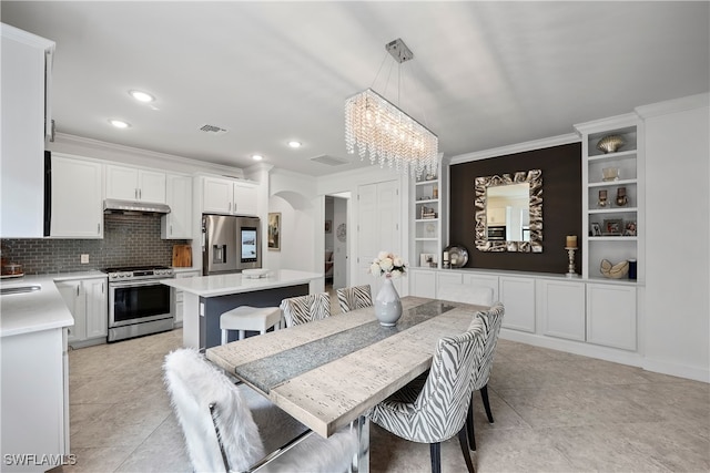 tiled dining area with built in features, ornamental molding, and a chandelier