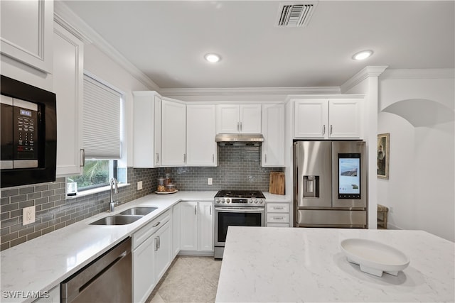 kitchen with appliances with stainless steel finishes, decorative backsplash, white cabinetry, and sink