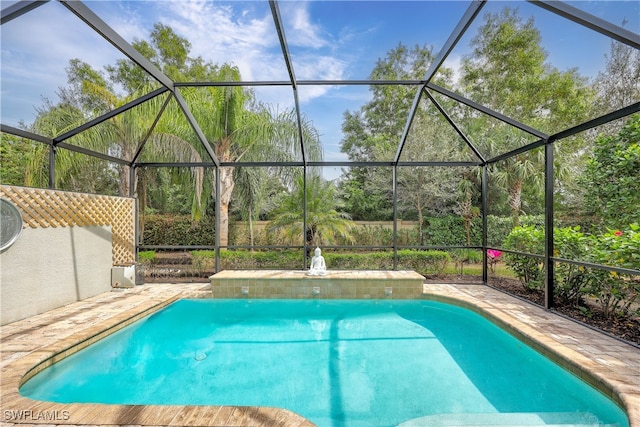 view of swimming pool featuring glass enclosure