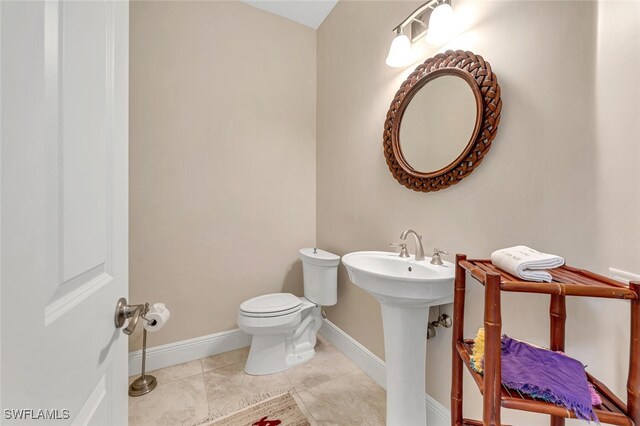 bathroom with toilet and tile patterned floors