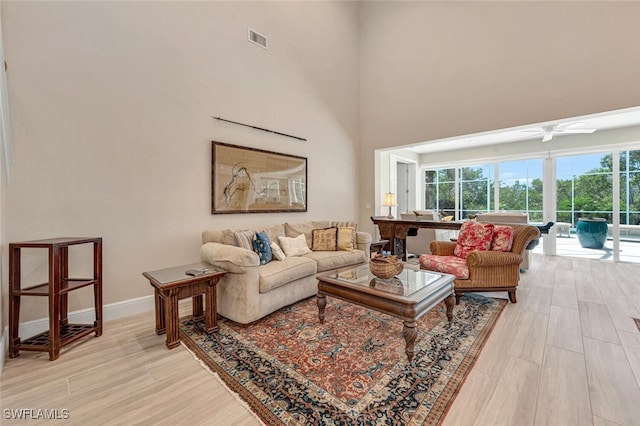 living room featuring ceiling fan and light hardwood / wood-style floors