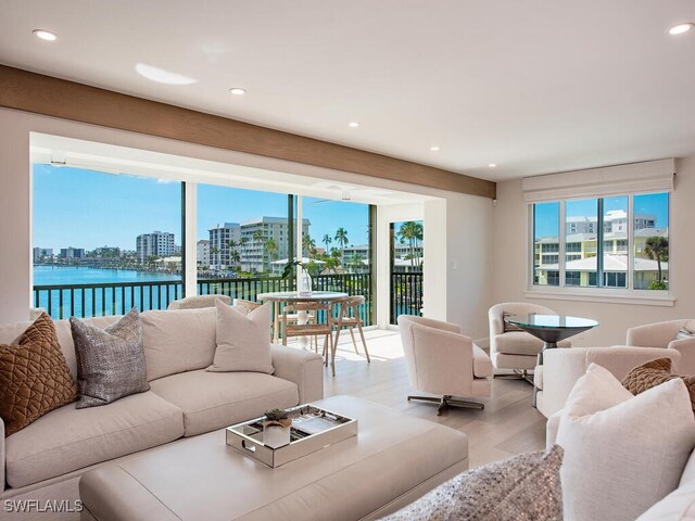 living room with light wood-type flooring and a water view