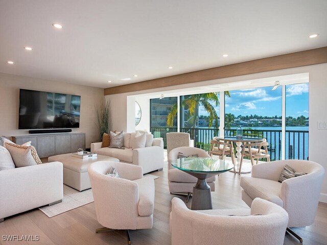 living room featuring light hardwood / wood-style floors and a water view