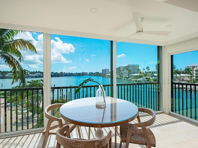 sunroom featuring a water view and ceiling fan