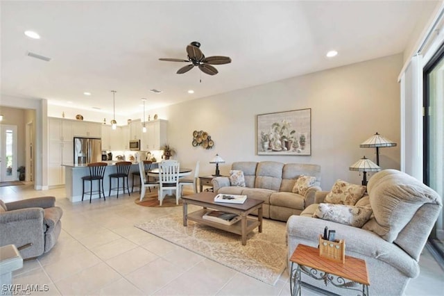 tiled living room with a wealth of natural light and ceiling fan