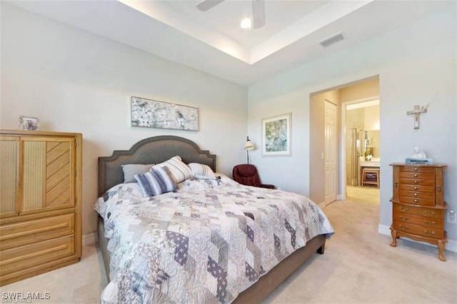 carpeted bedroom featuring ceiling fan, a raised ceiling, and a closet