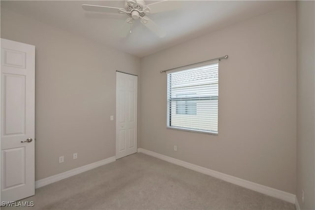 spare room featuring ceiling fan and light colored carpet