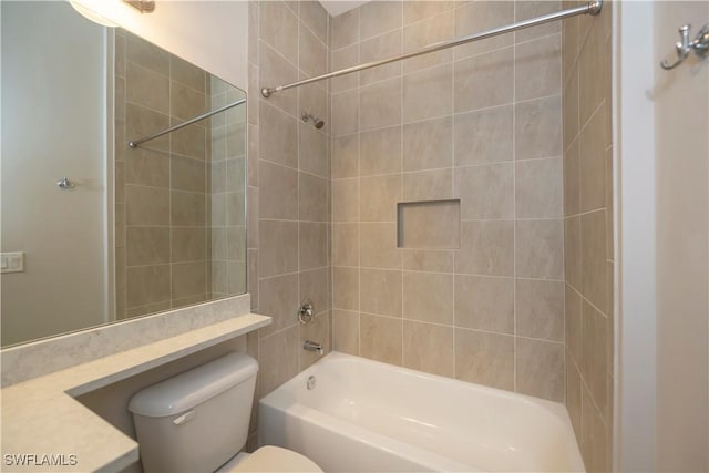 full bathroom featuring vanity, tiled shower / bath combo, and toilet