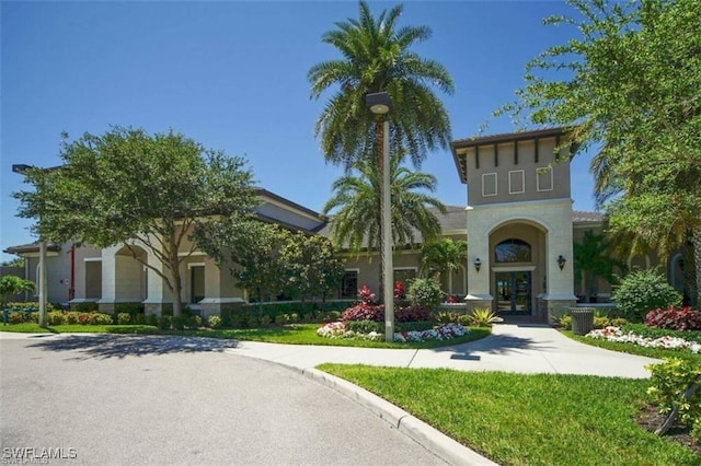 view of front of house with french doors and a front lawn