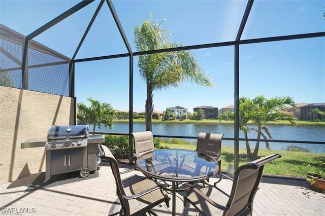 view of patio with a lanai, a grill, and a water view