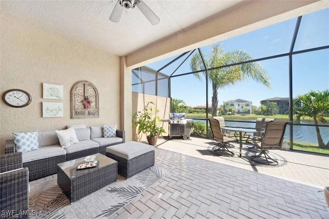 view of patio featuring glass enclosure, an outdoor living space, a water view, and grilling area