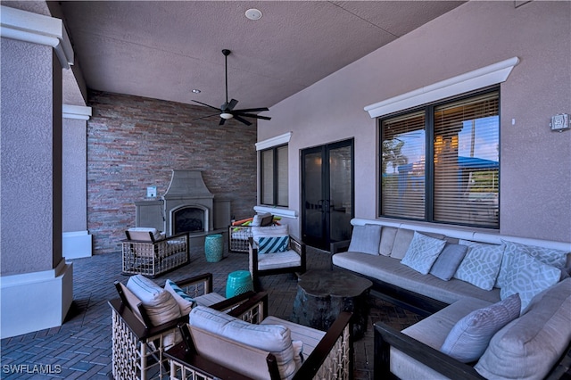 view of patio featuring an outdoor living space with a fireplace and ceiling fan