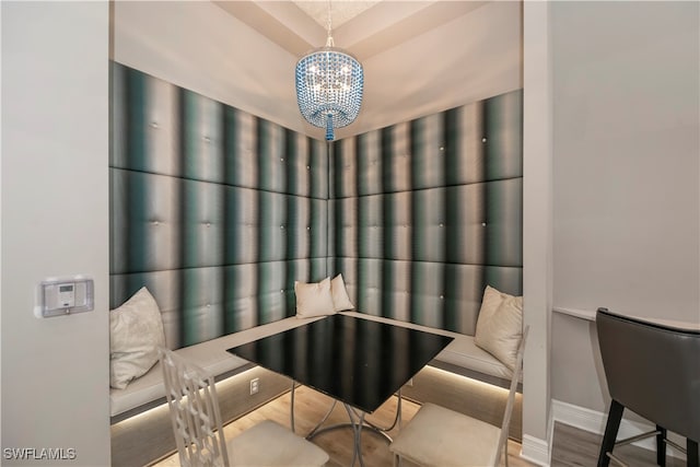 dining area with hardwood / wood-style floors and a notable chandelier