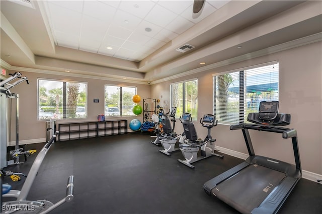 exercise room featuring a drop ceiling and a raised ceiling