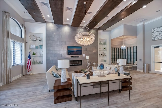 living room with a notable chandelier, crown molding, and light hardwood / wood-style flooring