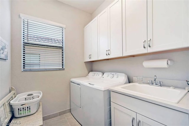 laundry room with light tile patterned flooring, separate washer and dryer, cabinets, and sink