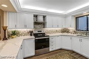 kitchen with a sink, stainless steel electric range, wall chimney exhaust hood, dark wood finished floors, and crown molding